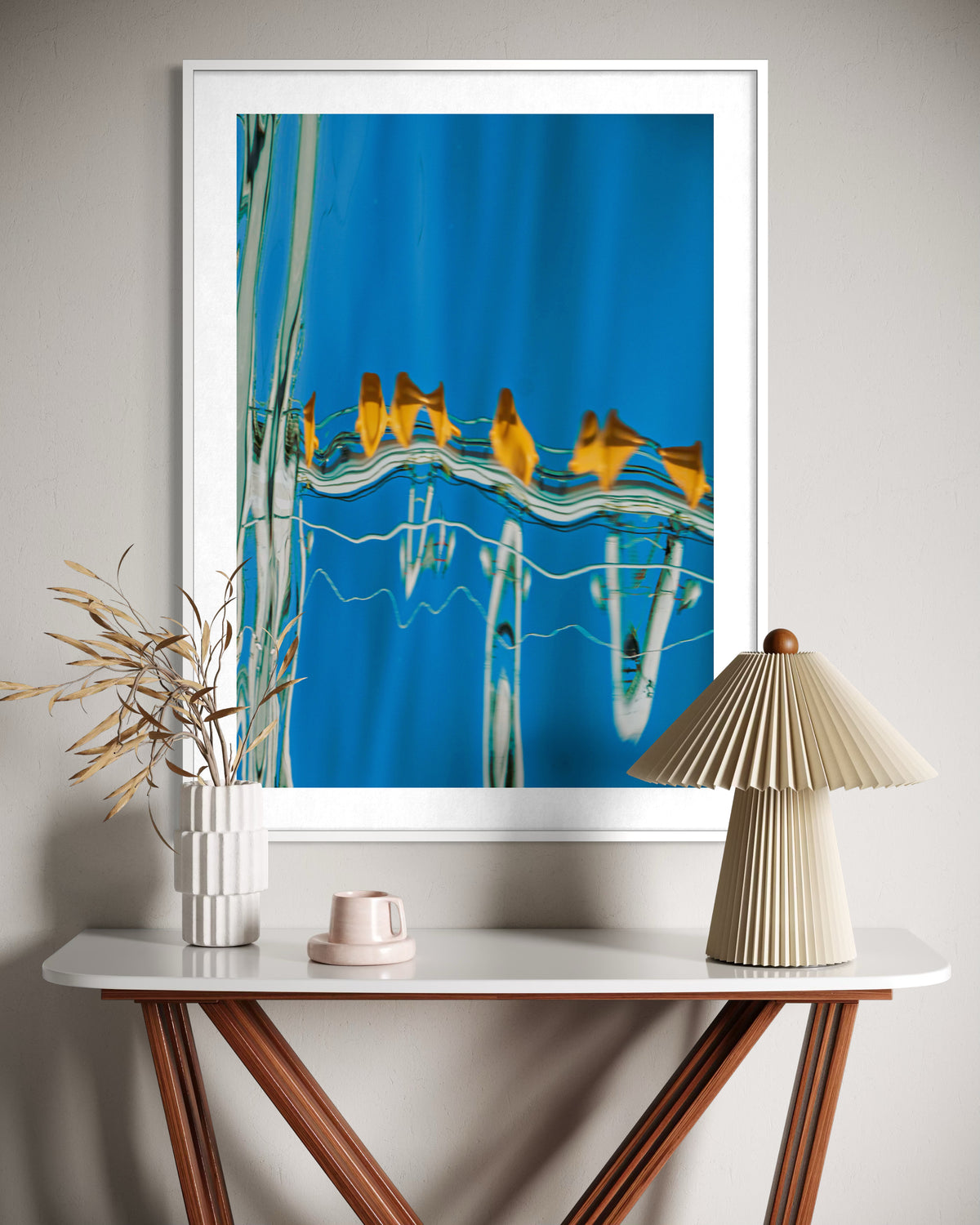 The Water Ballet by Ralph Kerle, in situ, a framed blue abstract artwork above a wooden console table.