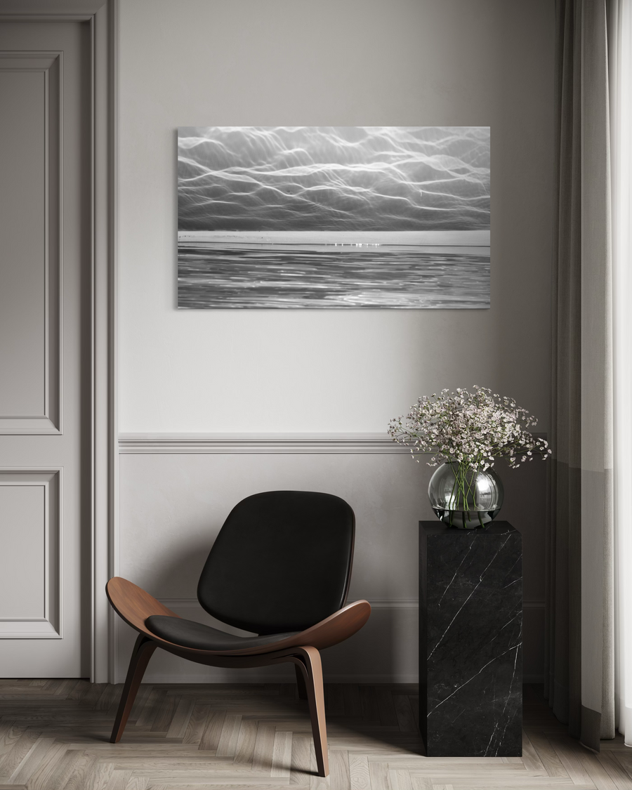 City of Light metallic artwork displayed above a chair in a minimalist interior with neutral tones.