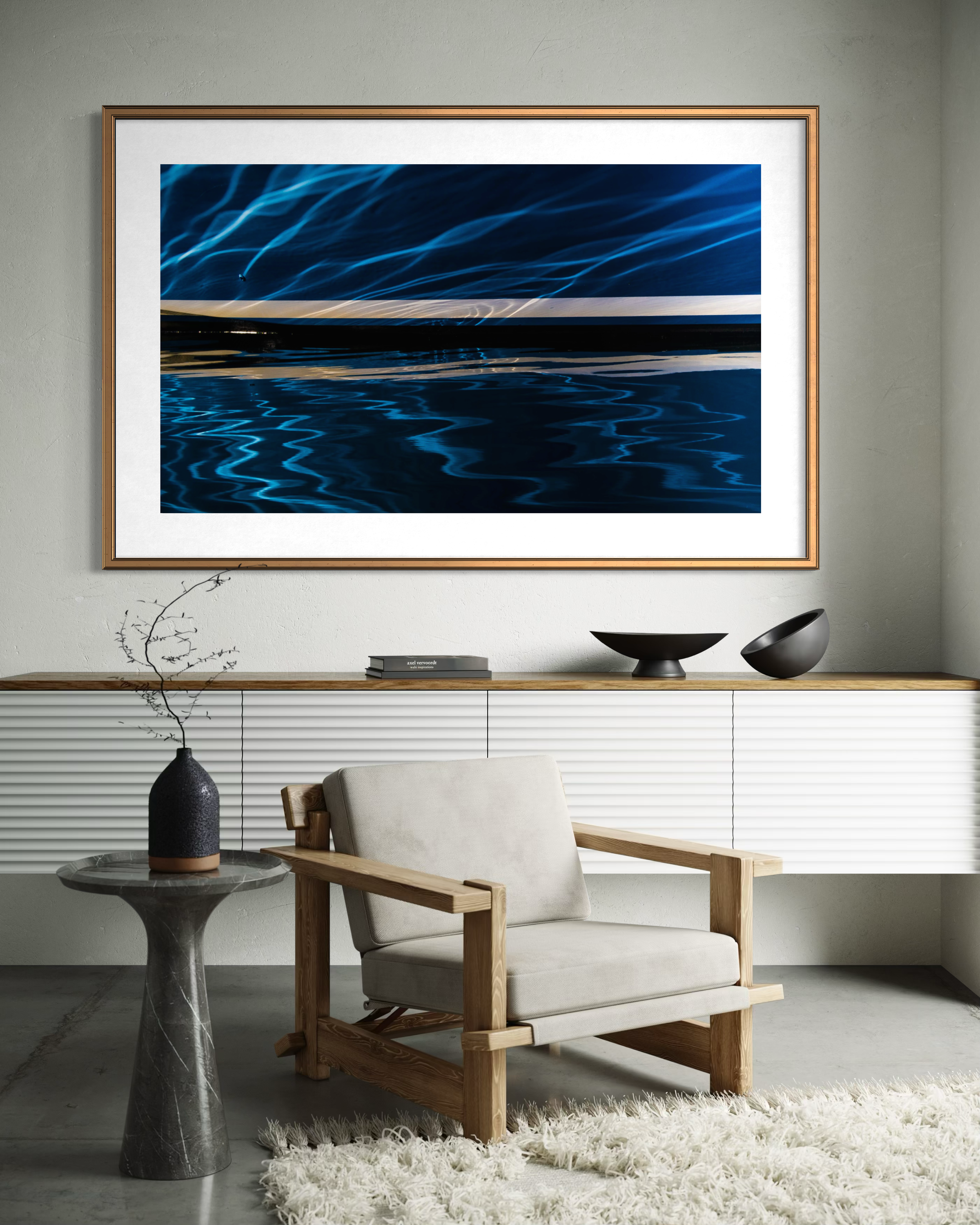 Clearing the Inner Blueness 1 by Ralph Kerle positioned above minimalistic modern decor in a warm with layered textiles and decorative accents that balance the bold colours of the artwork  