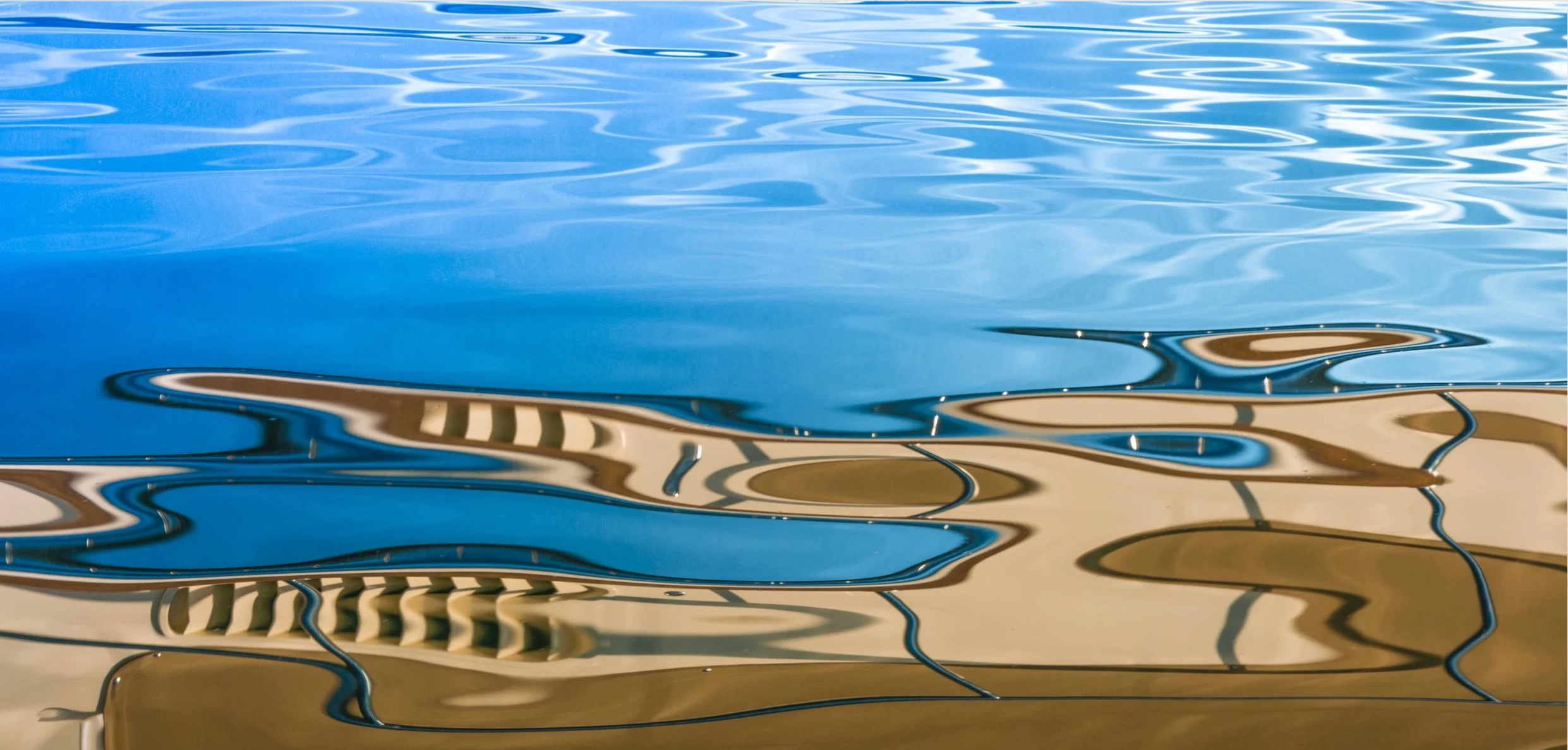 Ripples on water surface with reflections of sand patterns