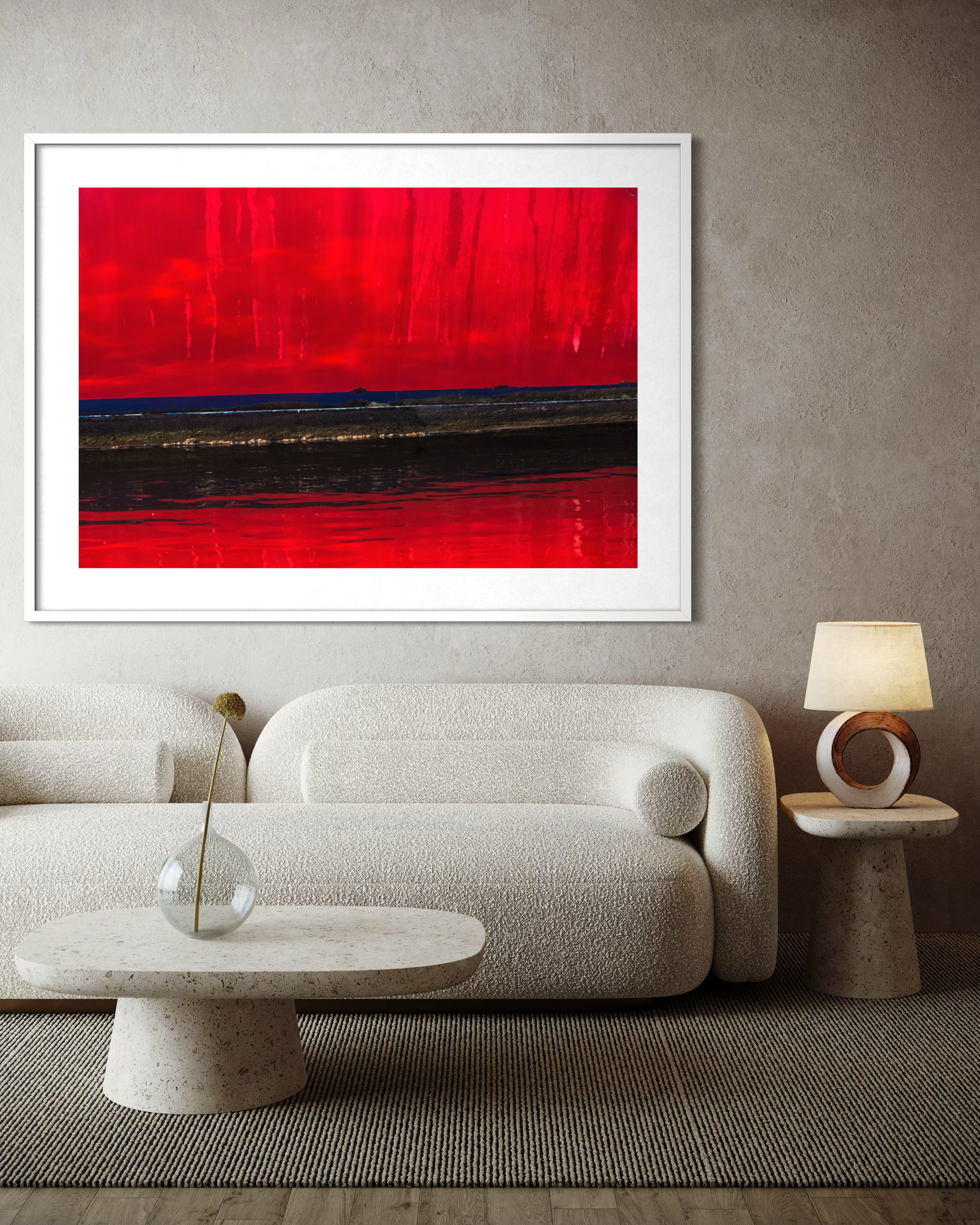 Red Rain on the Peace Parade by Ralph Kerle positioned above a sofa in a warm, lived-in living space with layered textiles and decorative accents that balance the bold colours of the painting