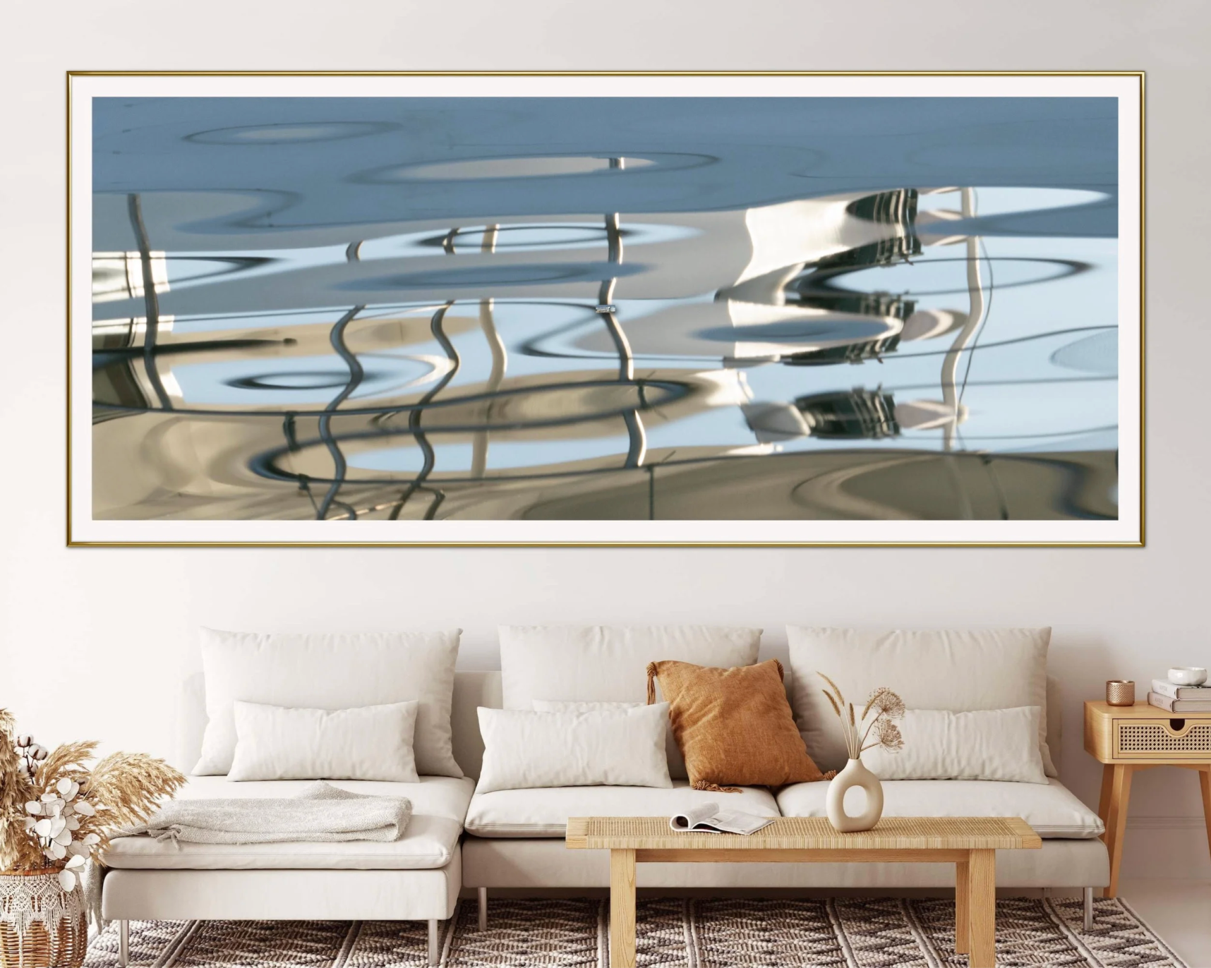 Framed abstract artwork on a wall above a beige sofa with decorative pillows.