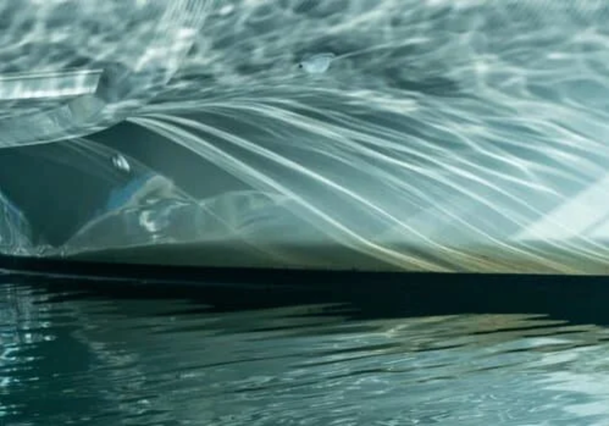 Close-up of a car windshield with water droplets and a blurred background