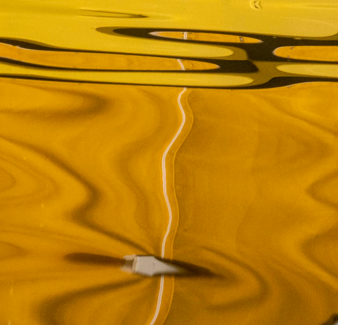 Ripples on a yellow surface with a white line running through them